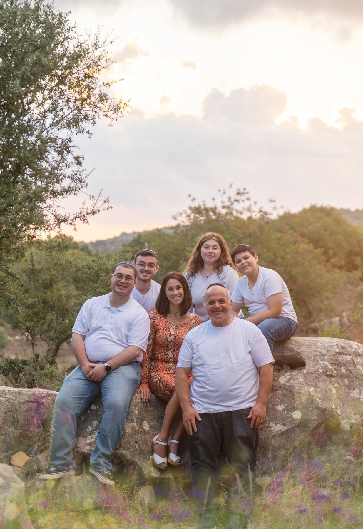 משפחה על סלע מול הרי הגליל בשקיעה