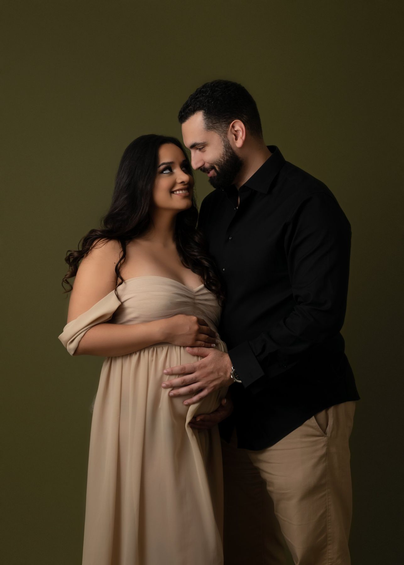 Maternity couple portrait on an olive backdrop