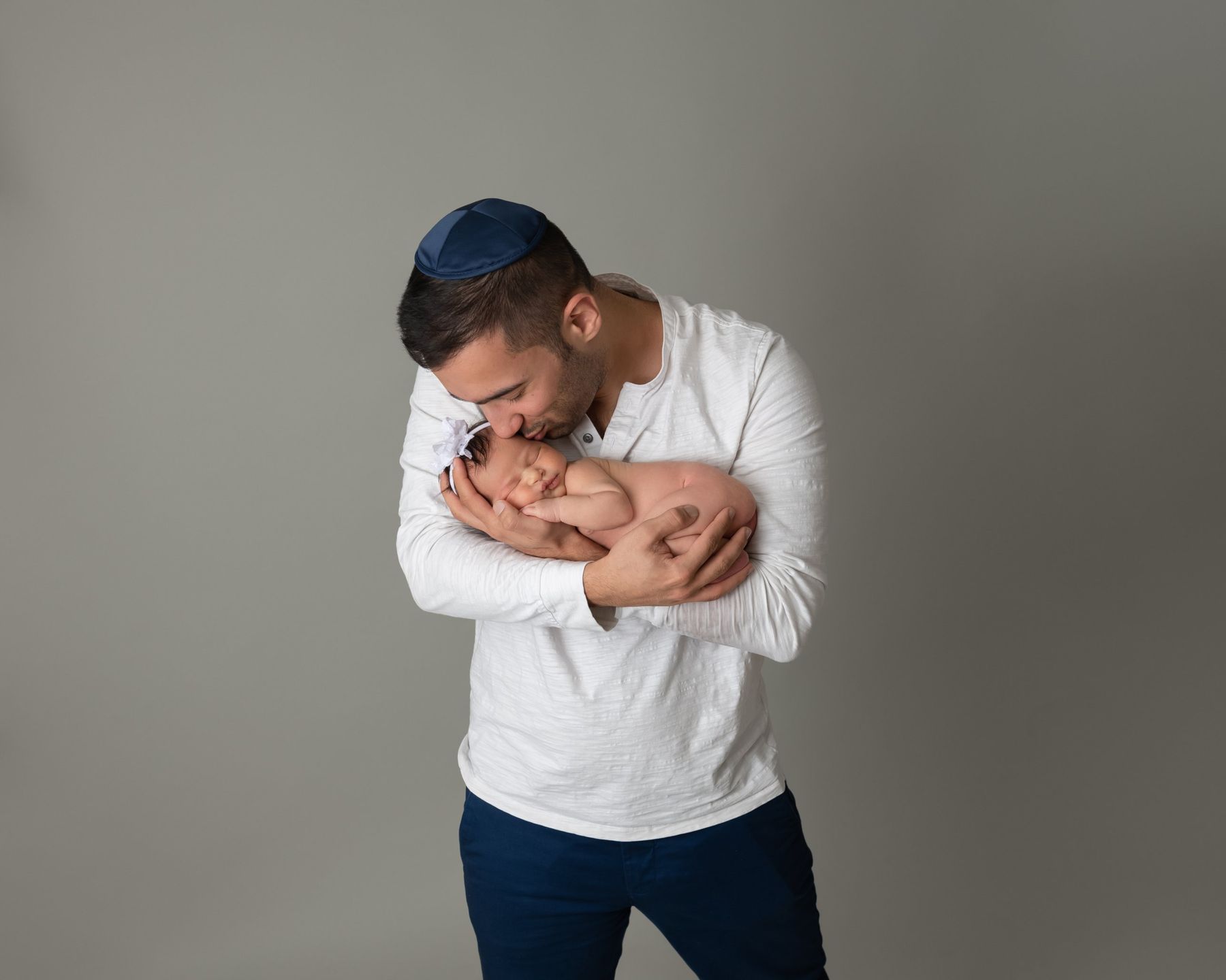 אבא מנשק את התינוקת על רקע אפור