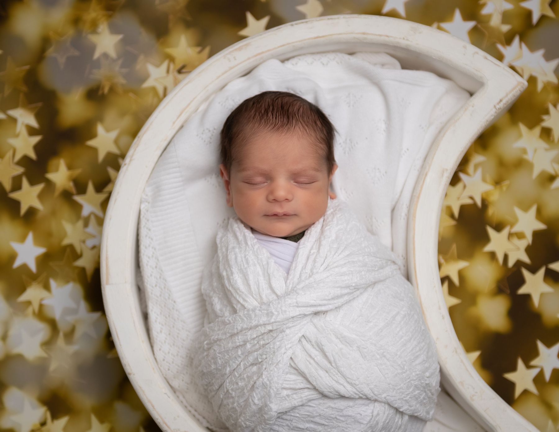 Newborn in a moon bowl with golden stars