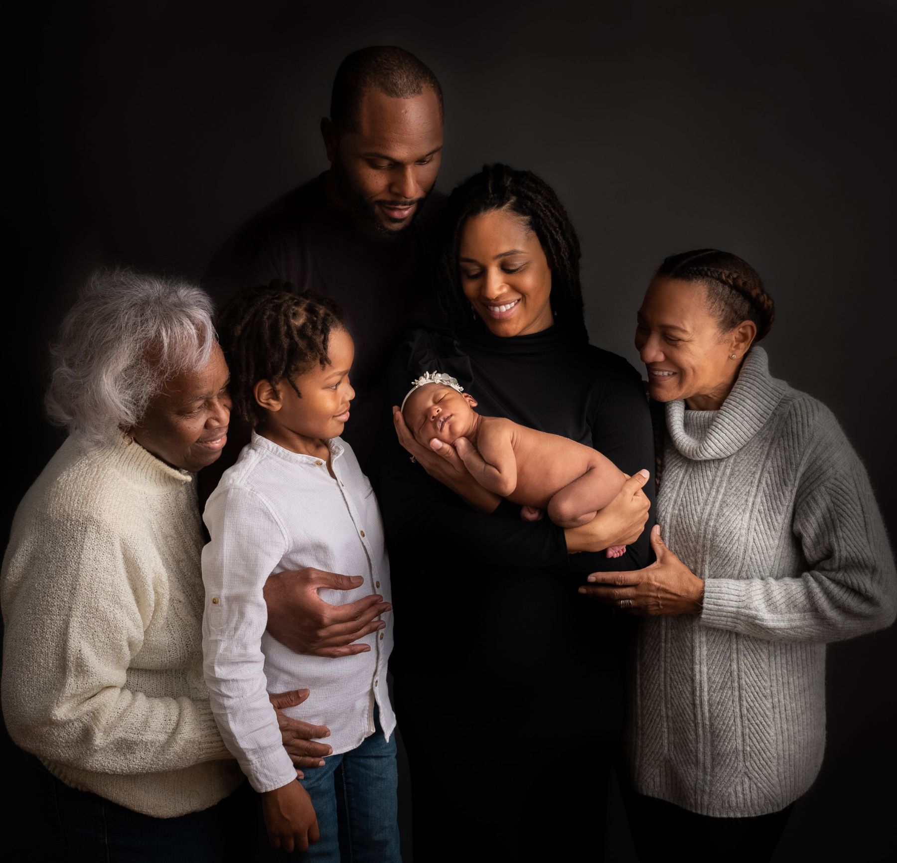 Three-generation family portrait with the newborn