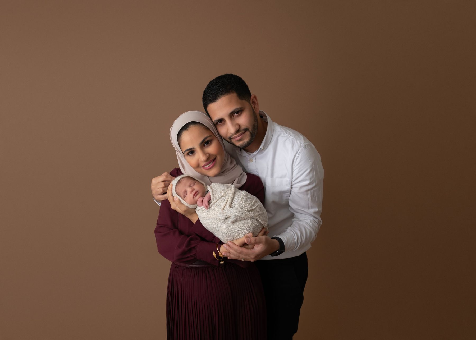 Parents holding their newborn in the studio